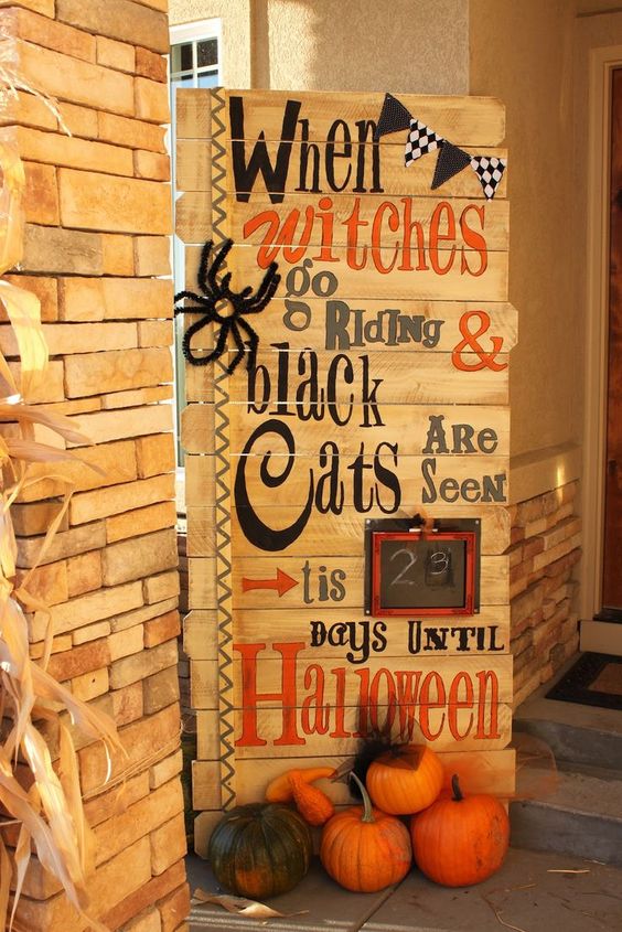 a gorgeous pallet sign with ribbons, a black and white banner, a faux spider and a frame