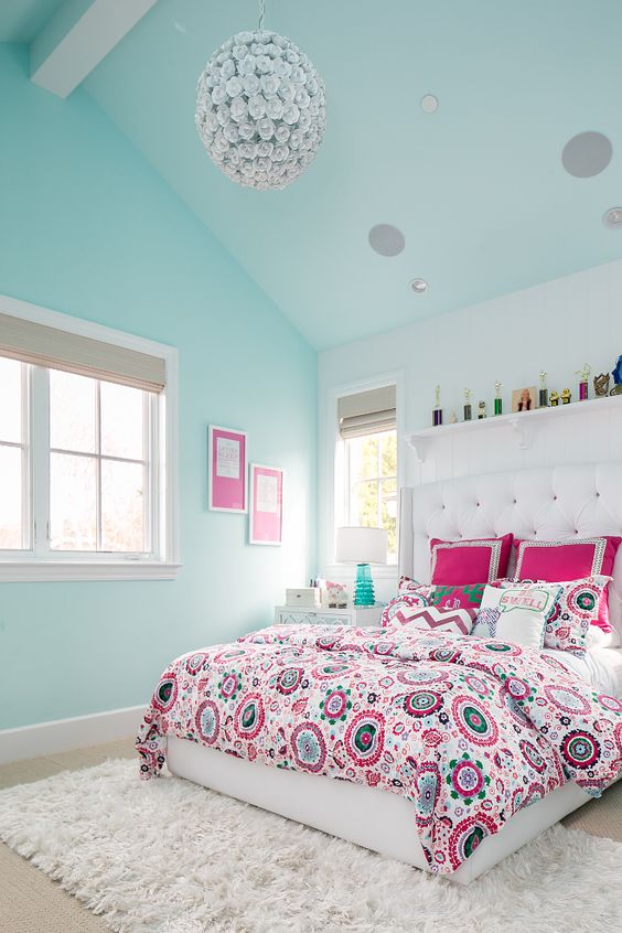 pink and turquoise bedding with various prints matches the same statement wall