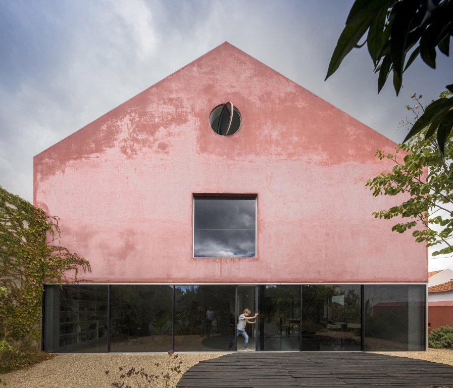 This house is a renovated old winery, which was covered with red mortar to highlight its presence and make it look unique