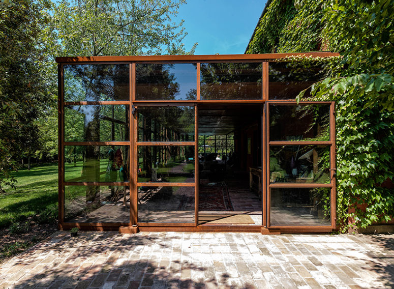 The glass volume is made of glass and corten, and such glazings make one feel outside while being inside