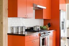 02 a bold orange kitchen with a simple modern design looks cheerful and fun
