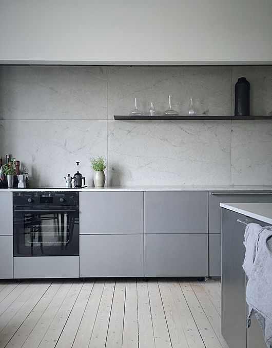 a minimalist grey kitchen with a grey marble backsplash and white countertops for a fresh touch