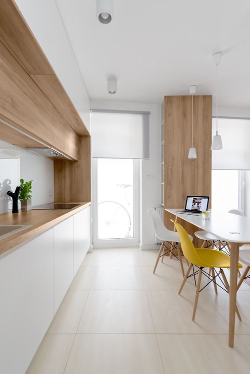 a modern white kitchen with wooden counters and some cabinets for more coziness