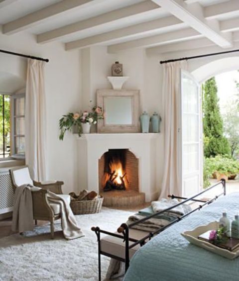 a real fireplace in the corner of your bedroom is sure to add coziness and create a welcoming atmosphere