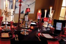 03 a black and deep red party table with red candles and candle holders, red napkins with a black tablecloth