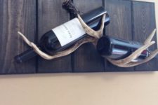 03 a creative wine rack made of stained wood and antlers is a nice and easy DIY