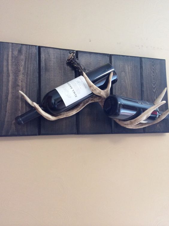 a creative wine rack made of stained wood and antlers is a nice and easy DIY