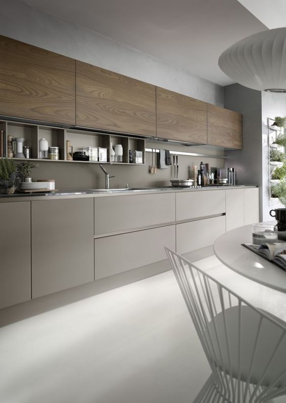 a grey kitchen with wooden cabinets and a grey backsplash, with built-in shelves and nickel touches looks very modern