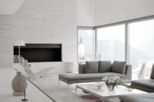 03 a neutral space with a textural fireplace wall, large windows and comfy grey furniture