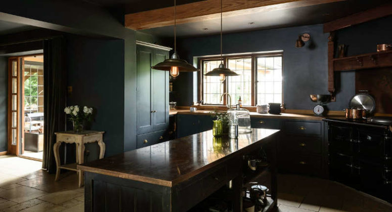 There's a large kitchen island with storage, some vintage accessories like scales and industrial pendant lamps