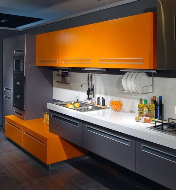 a minimalist kitchen wit graphite grey and orange cabinets looks contrasting and very bold