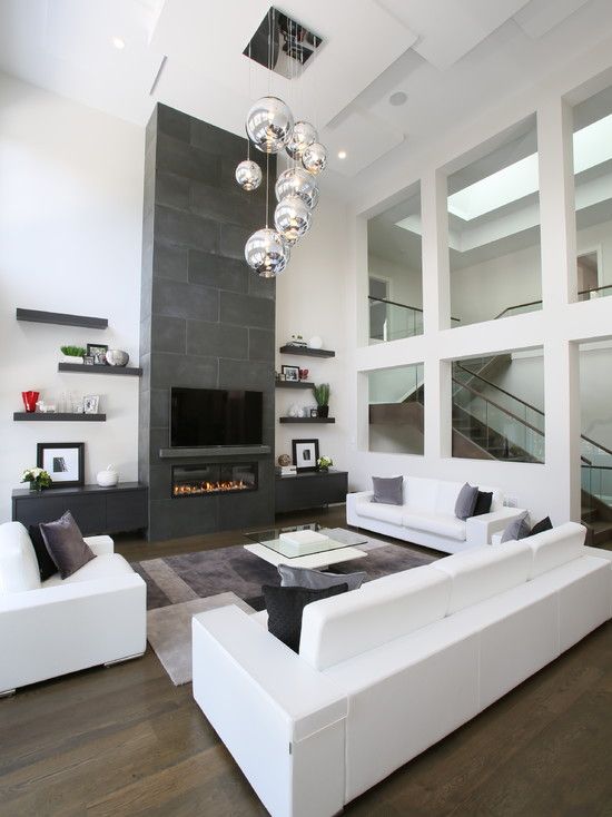 a neutral space is highlighted with dark floors and a dark concrete fireplace, bubble lights add interest