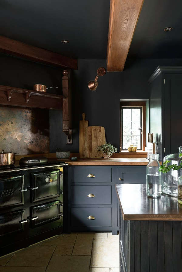There's a vintage cooker, some brass fixtures and pans and wooden beams on the ceiling