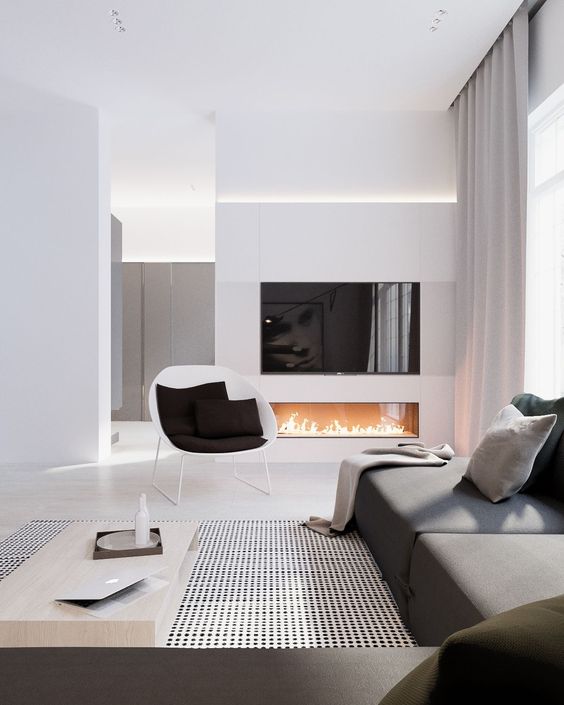 an elegant space with a graphite grey sofa, a built-in fireplace and lots of white color