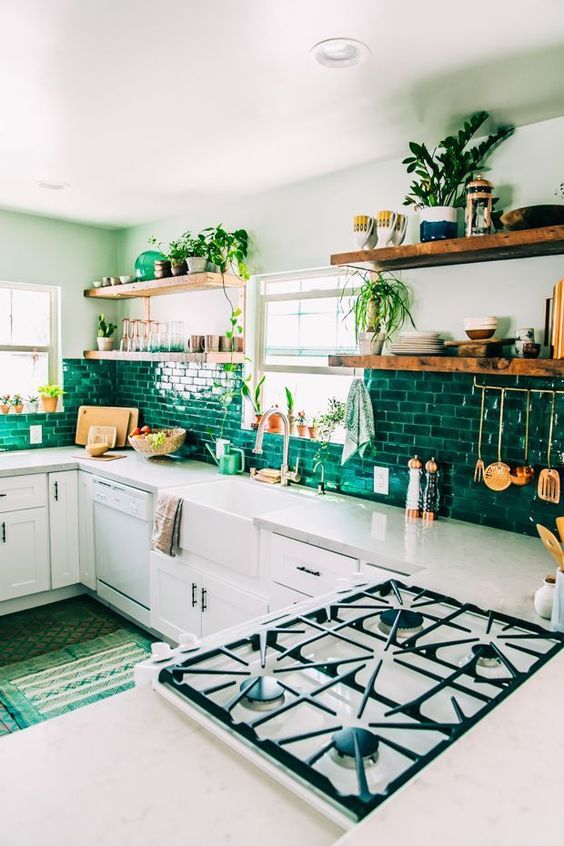 An emerald tile backsplash is a colorful and bright feature in this light colored kitchen