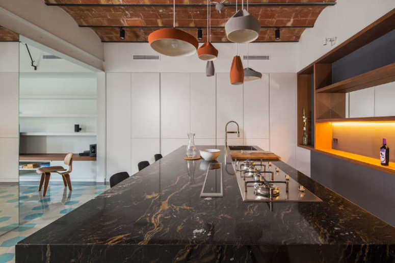 The kitchen island is covered with dark marble and highlighted with eye-catchy porcelain lamps