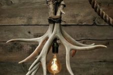 06 a cabin-inspired chandelier made rope, antlers and a bulb for a bold rustic touch