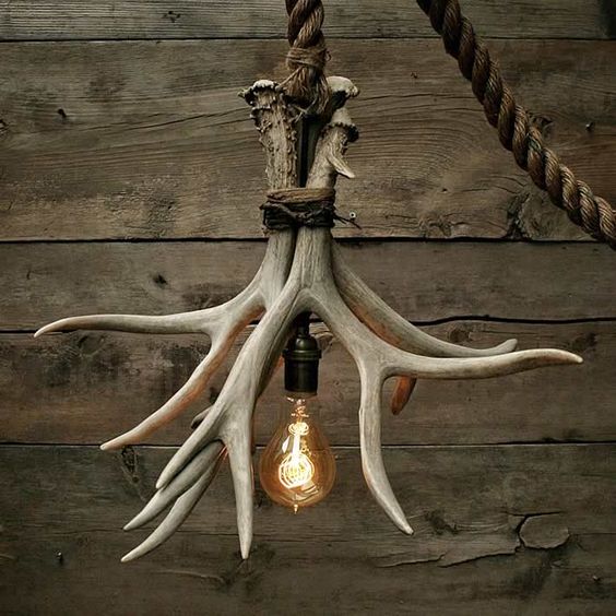 a cabin-inspired chandelier made rope, antlers and a bulb for a bold rustic touch