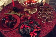 06 an elegant punch table with bloody punch and bloody apples, black and red candles