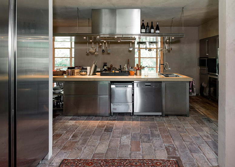 The kitchen is stainless steel, with concrete and brick floors, which altogether create a cool industrial feel