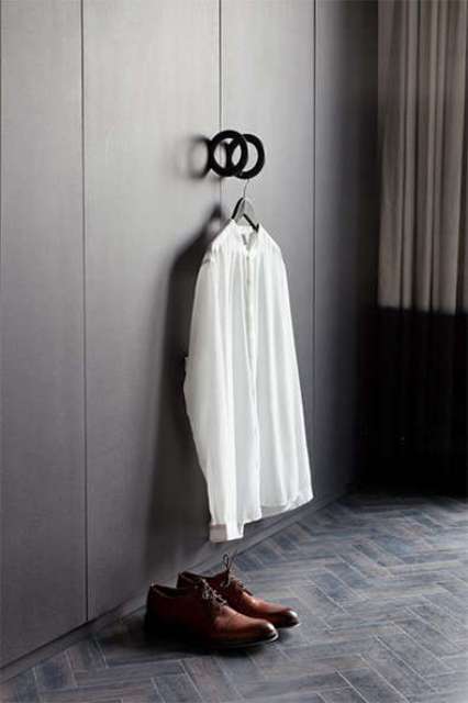 The wardrobe is sleek and dark, with round handles, which can be used for haanging clothes