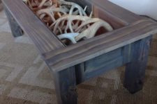 07 a coffee table of reclaimed wood with antlers inside and a glass tabletop to enjoy looking at them