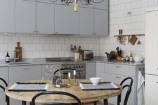 07 a simple modern light grey kitchen is psruced up with a gorgeous chandelier and a stylish dining set with black touches