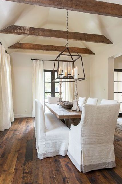 a shabby chic dining room features a vaulted ceiling with exposed wooden beams