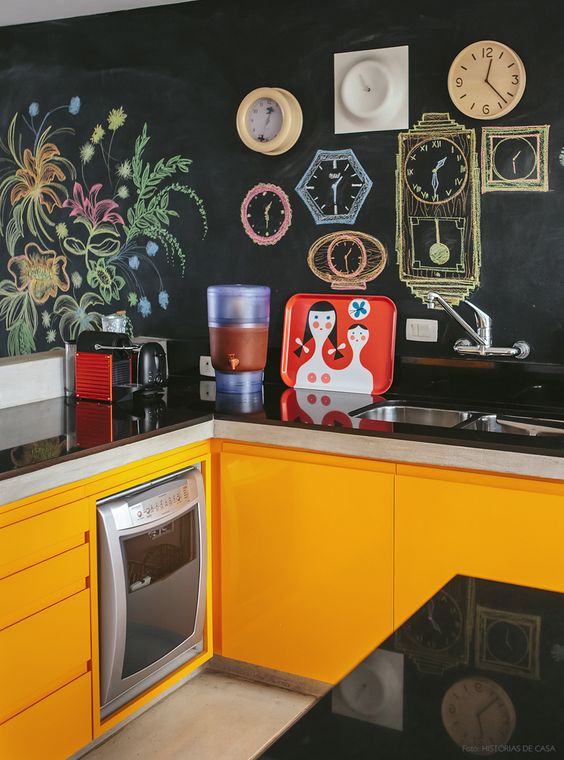 orange kitchen cabinets with sleek black countertops and chalkboard walls for a family retreat