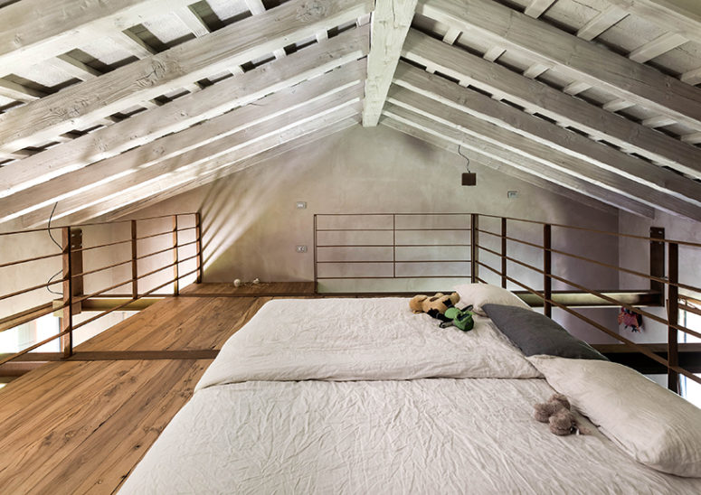 The attic space is used for a bedroom, where you can see only exposed wooden beams and two beds - what else do we need for a cozy nap