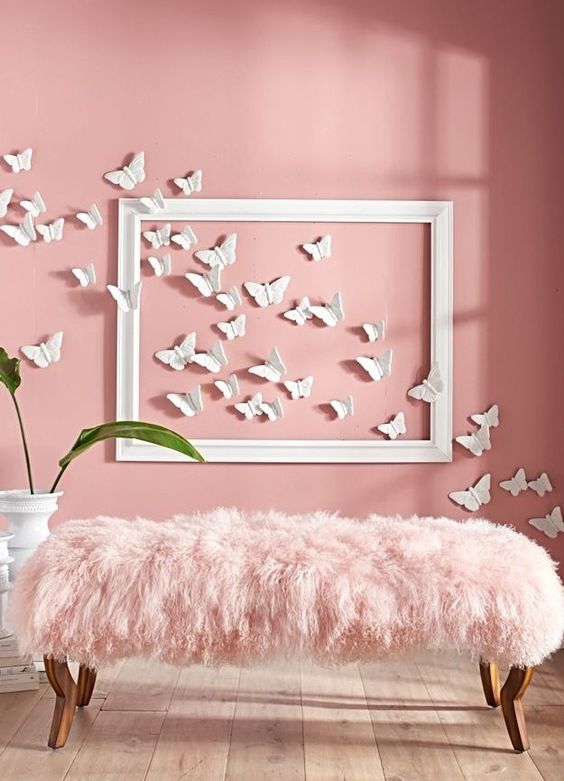a hot pink wall with butterflies and a pink fur bench look chic together