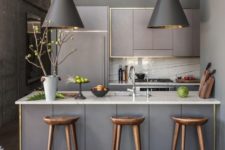 09 a modern grey kitchen with chic pendant lamps over the kitchen island and wooden stools leaves an impression