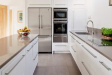 09 a modern white kitchen with stainless steel counters, handles and appliances