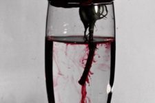 10 a glass with a red rose and fake blood as a centerpiece of decoration