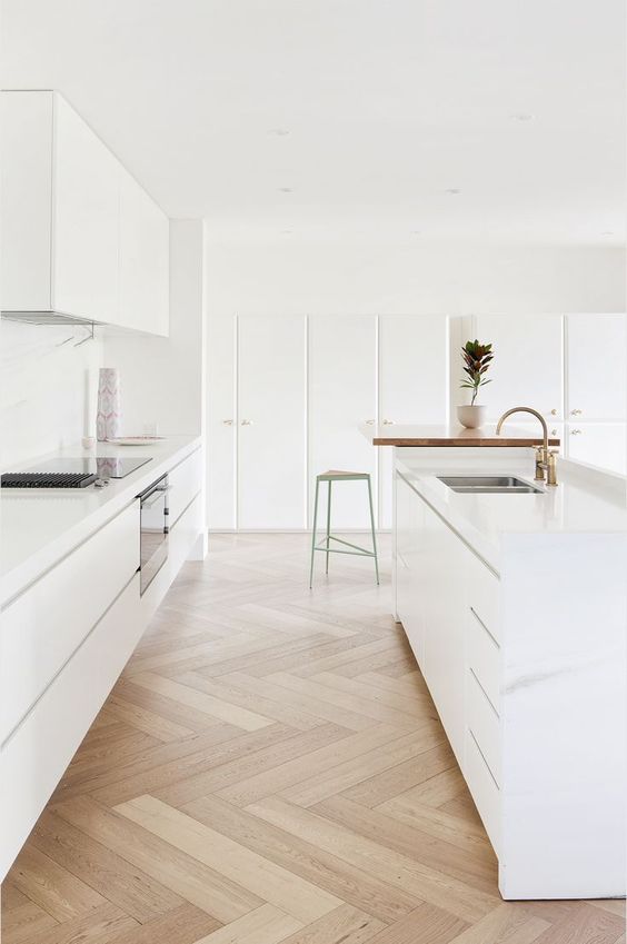 A modern all white kitchen with sleek cabinets looks ethereal and airy