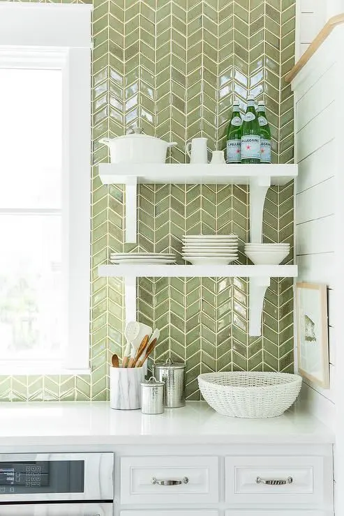 white cabinets are paired with white quartz countertops and a ceiling height green herringbone tiled backsplash