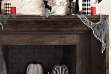 12 a stylish mantel with bats and red and checked candles and a fireplace filled with checked, striped and red pumpkins