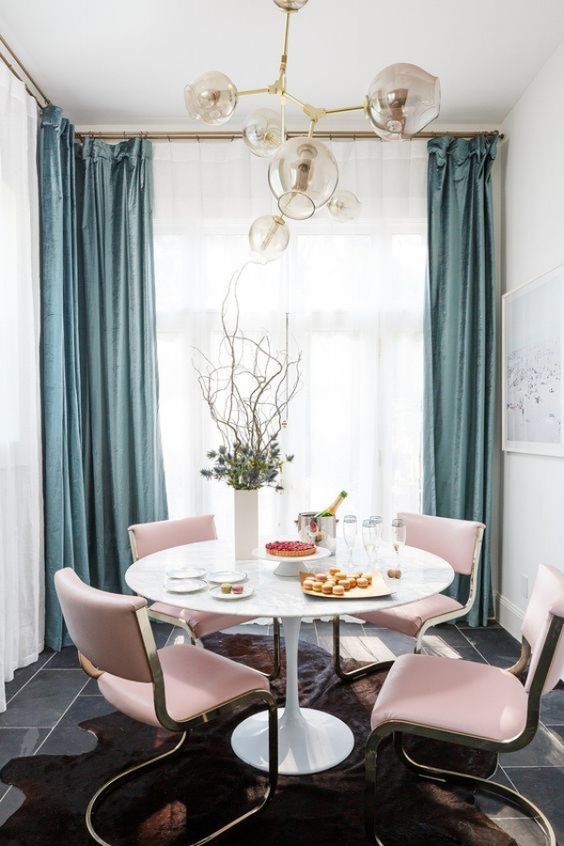 chic pink chairs add color to this glam dining space