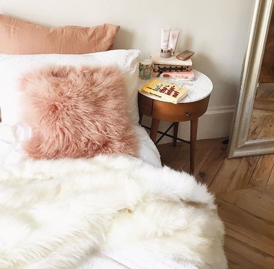 a pink faux fur pillow and a white blanket to add a girlish feel and comfort to the bedroom