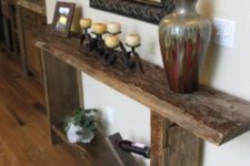 14 a reclaimed wood console with a wine stand and a large vase brings a rustic feel to the space