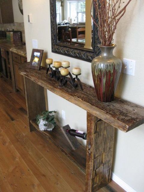 a reclaimed wood console with a wine stand and a large vase brings a rustic feel to the space
