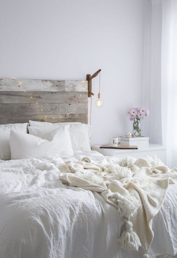 a reclaimed wooden headboard stands out in a neutral space and can be easily DIYed