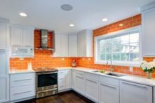 16 a bold orange tile backsplash extended on the walls gives color to the space