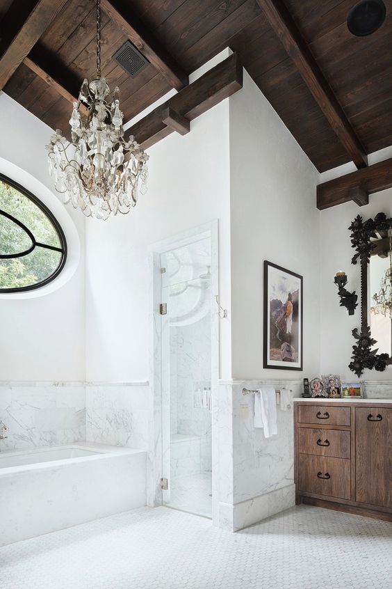 a dark colored wooden ceiling makes a statement in this light-colored bathroom