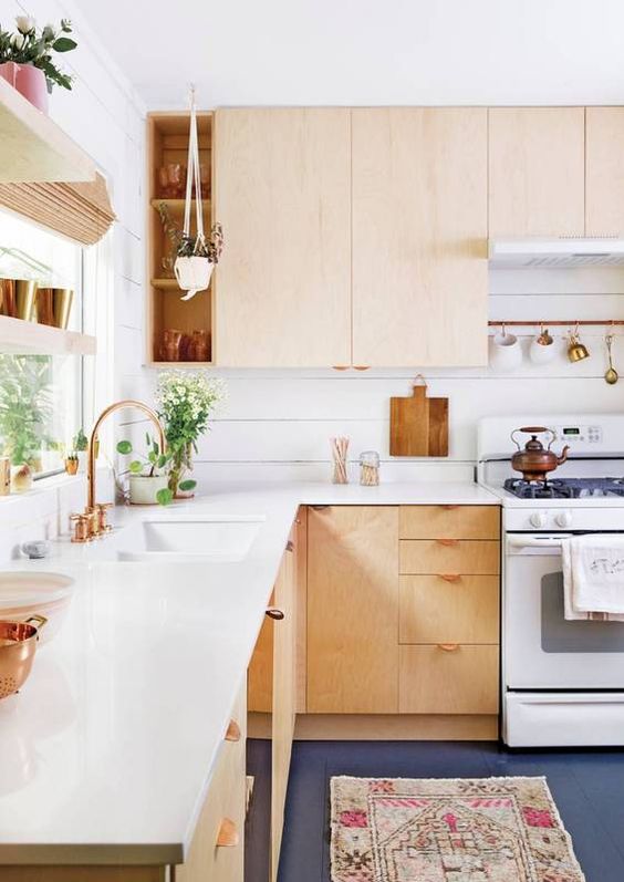 a light-colored wooden L-shaped kitchen with copper details looks warm and very welcoming