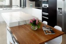 17 a modern black and white kitchen with a marble and wood kitchen island and a pendant lamp