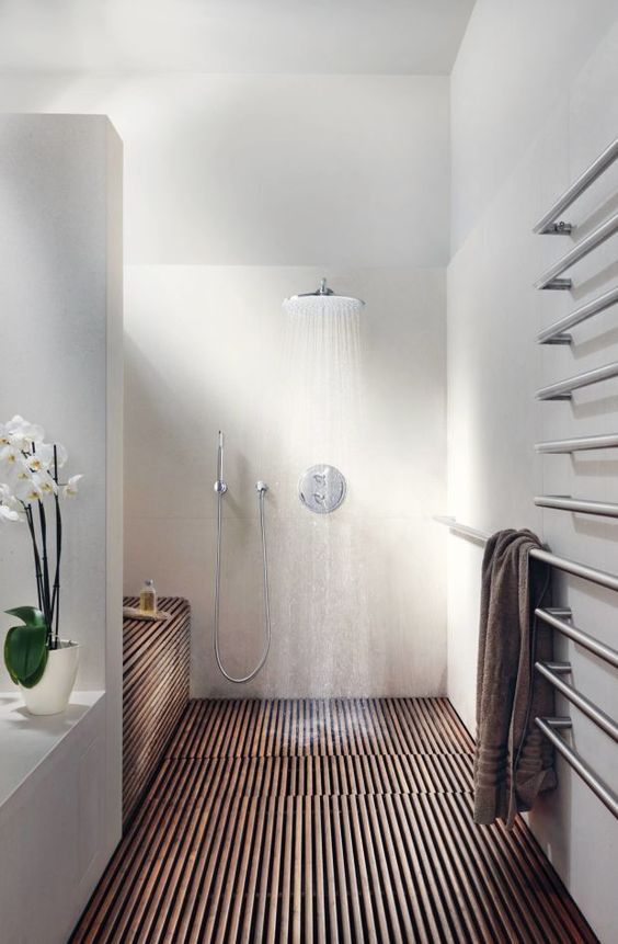 a modern space a with wood clad shower, matte white walls and an orchid for a chic touch