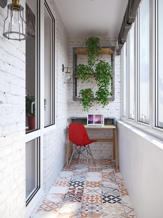 an industrial home office with a small desk, a tile floor and whitewashed brick walls