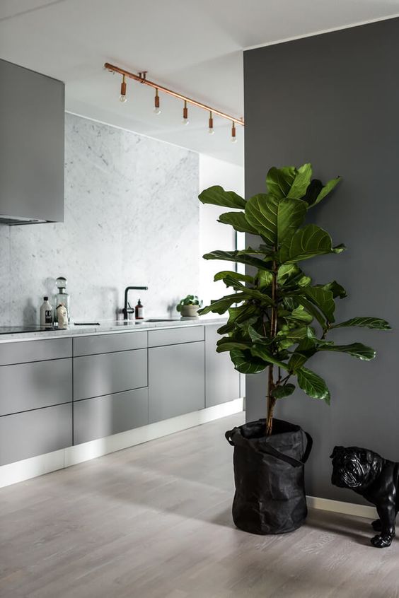 light grey kitchen with a marble wall, copper touches and grey walls for a modern sleek look