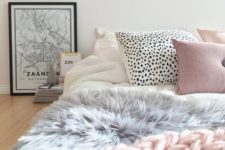 18 a cute girlish bed with a pink chunky knit throw, a faux fur grey blanket and creative printed pillows